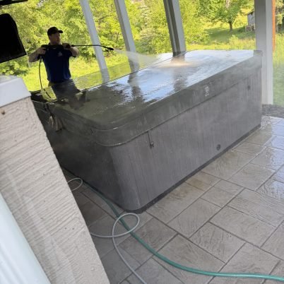 man spraying the top of a hot tub cover